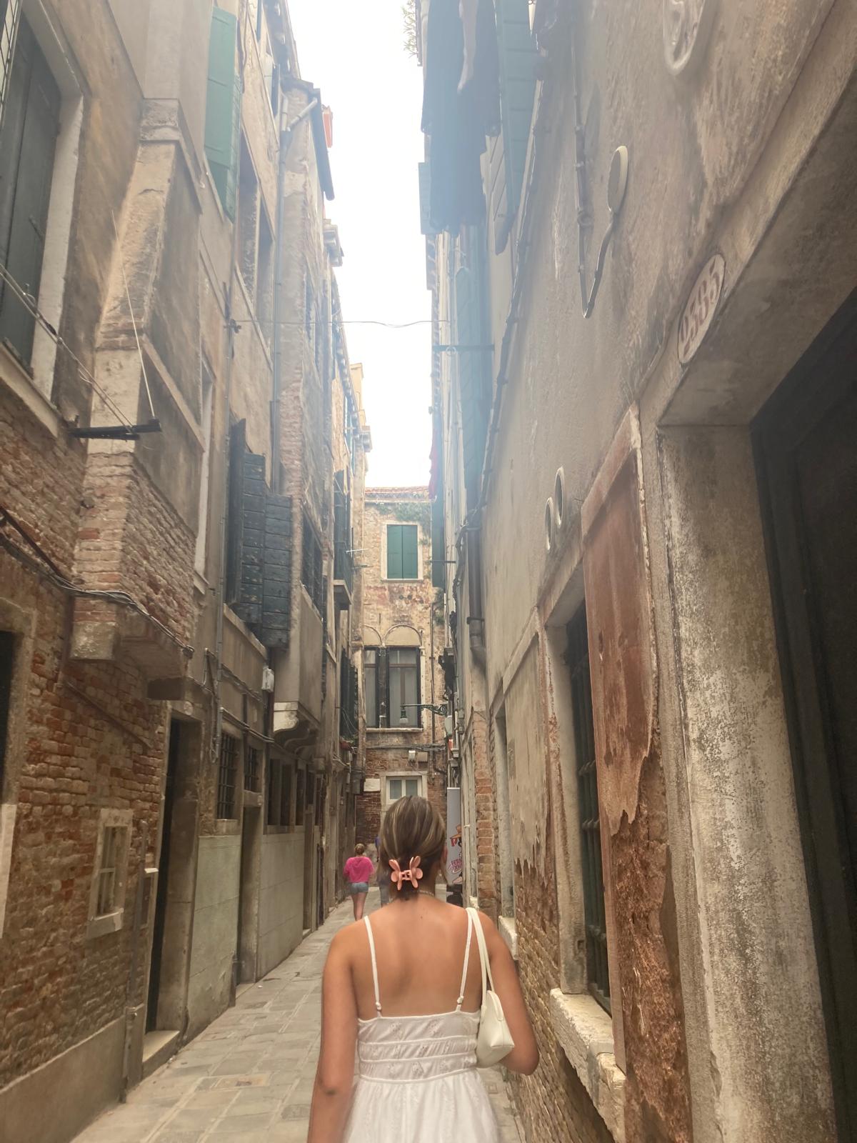 ein mädchen von hinten, welches durch eine enge gasse läuft